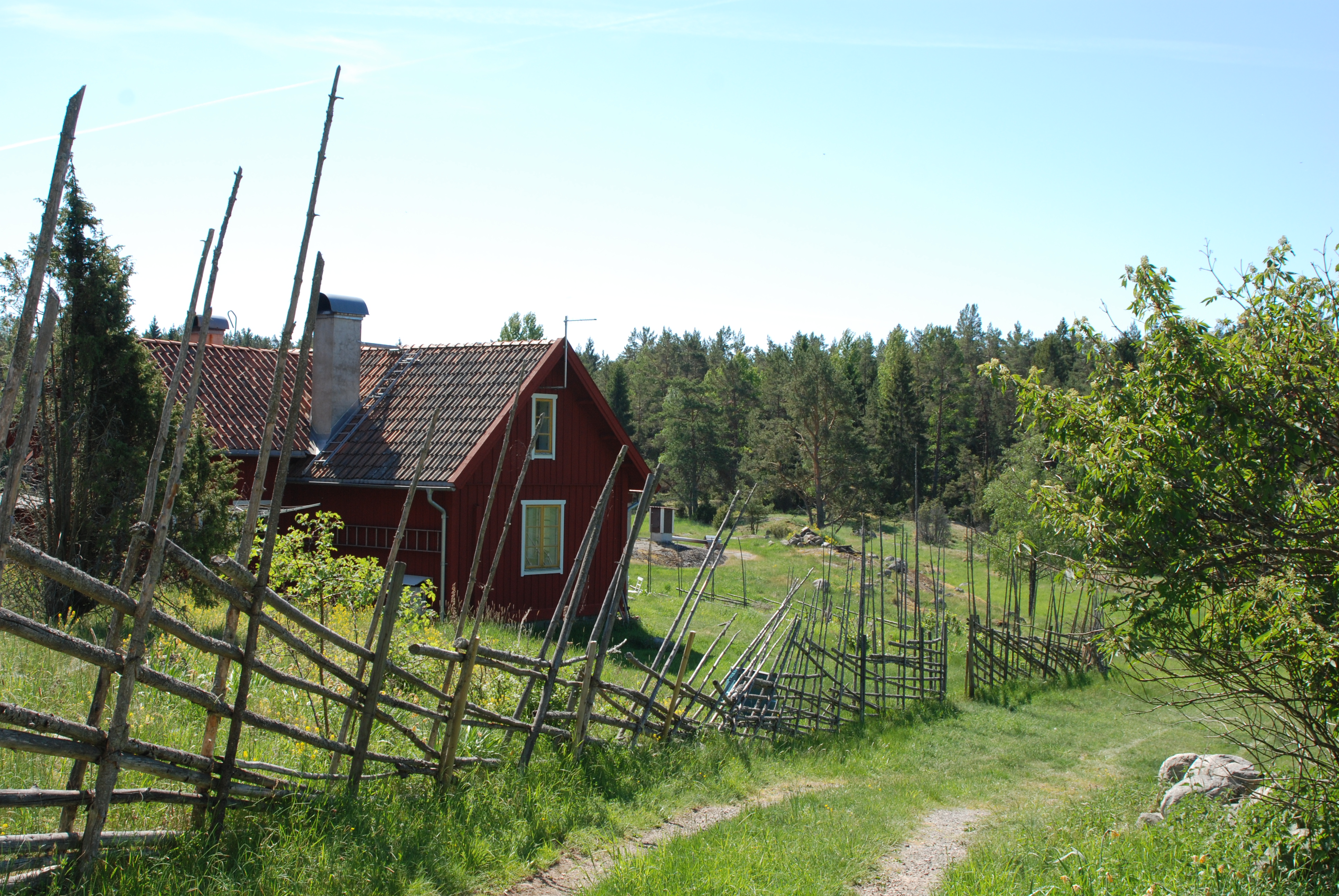 En röd stuga längs en landsväg på Ornö