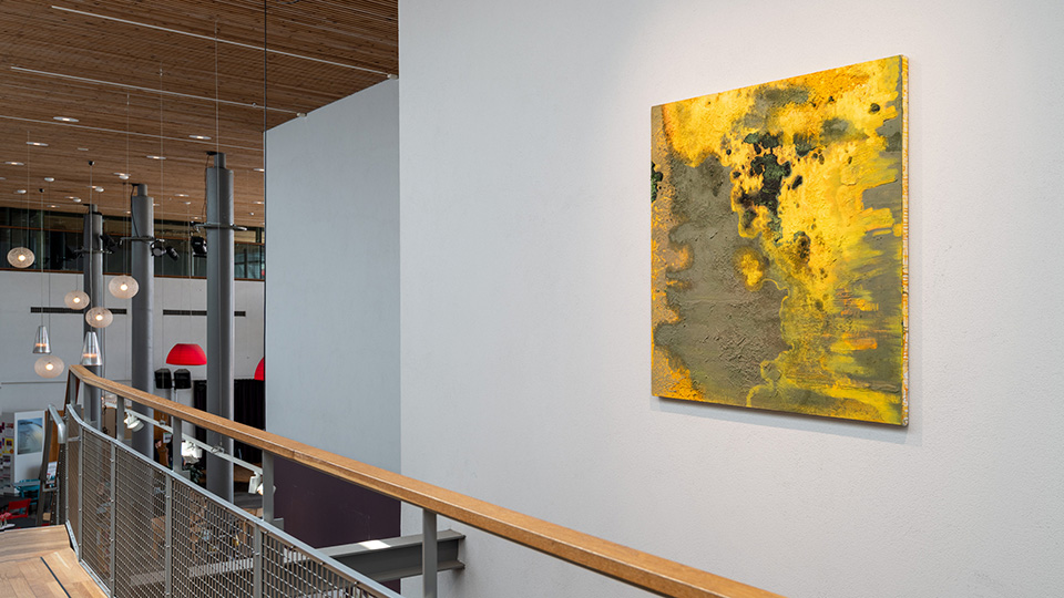 Gul tavla på en vit vägg.