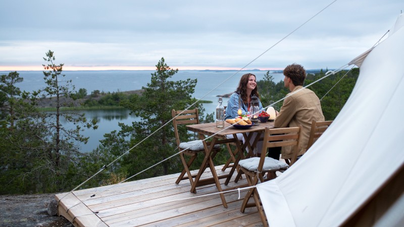 Par skrattar vid glamping tält Utö